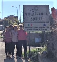Women standing in front of sign in Sicily